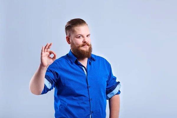 Um homem gordo e barbudo mostra um sinal com o dedo com um expresso — Fotografia de Stock