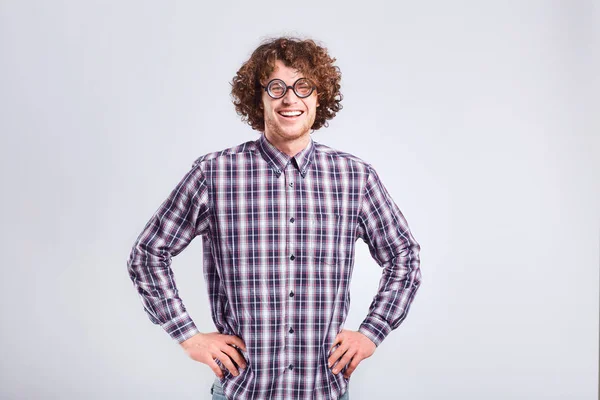 Curly nerd man in glasses with a stupid kind of funny emotion. — Stock Photo, Image
