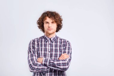 Kıvırcık saçlı bir adam ciddi bir duygu ile görünüyor.