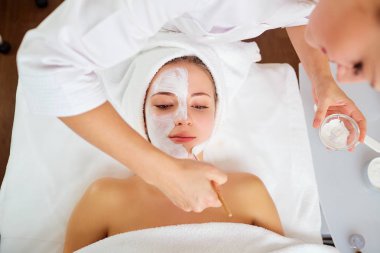 Güzellik salonunda maskeli bir kadın.