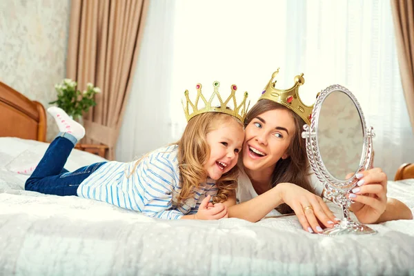 Mãe e filha com coroas na cabeça estão jogando no b — Fotografia de Stock