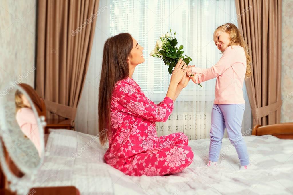 The daughter congratulates the mother with flowers on the holida