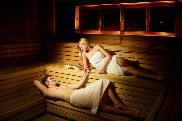 Pareja en toallas descansando en la sauna . — Foto de Stock