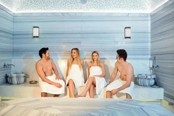 Un grupo de amigos en las toallas se ríen de la sauna — Foto de Stock