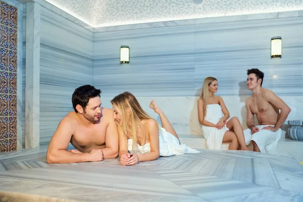 Un grupo de amigos en las toallas se ríen de la sauna — Foto de Stock