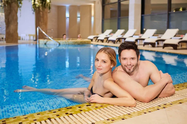 Casal em trajes de banho no centro de spa de descanso da piscina — Fotografia de Stock
