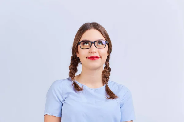 A young girl in pigtail glasses thinks, dreams with a positive e — Stock Photo, Image