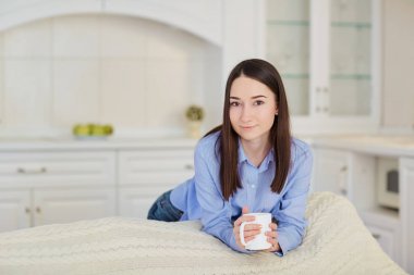   Mutfakta sıcak içecek bir fincan genç ciddi kızla