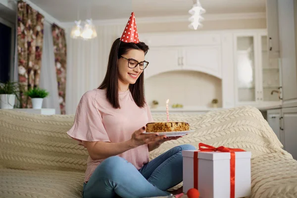 一个女孩在帽子单独与蜡烛坐在这样的蛋糕 — 图库照片
