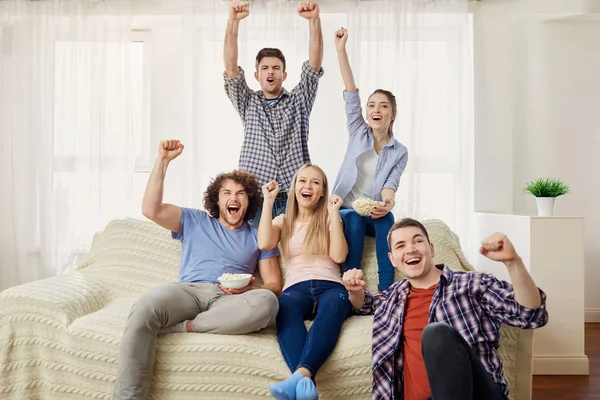 A group of friends of fans watching a sports TV sitting on a sof — Stock Photo, Image