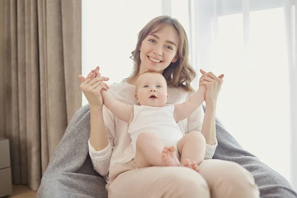 Mutter spielt mit Baby auf dem Bett. — Stockfoto