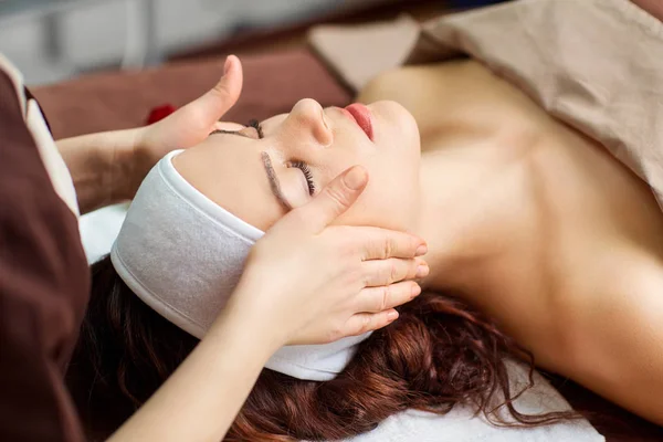 Vacker kvinna på en ansiktsbehandling massage på ett spasalong — Stockfoto