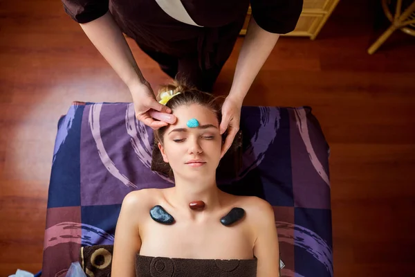 Massage de pierre est un massage du visage pour une femme dans la beauté cent — Photo