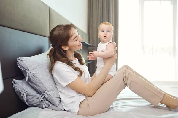 Madre jugando con el bebé en la cama . — Foto de Stock