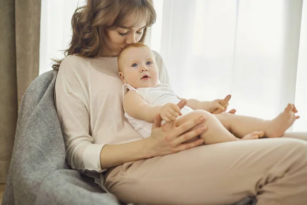 前の椅子に座って彼女の腕の中の赤ちゃんとお母さん — ストック写真