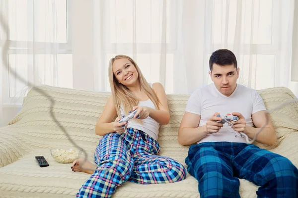 カップル ルームでソファの上に座ってビデオ ゲームをプレイ. — ストック写真