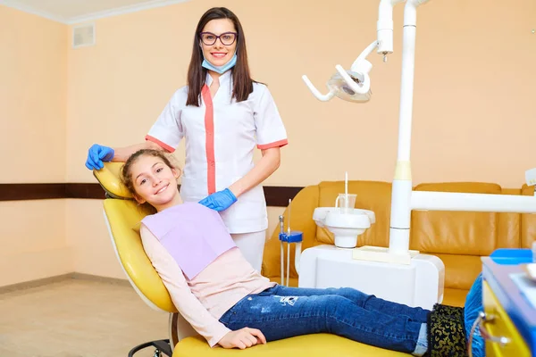 Dama dentysta leczy zęby dziecka w gabinecie stomatologicznym — Zdjęcie stockowe
