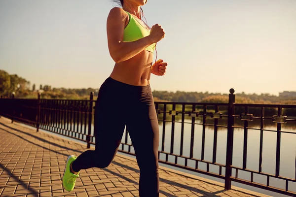 Una chica deportiva corre por el parque junto al lago . — Foto de Stock