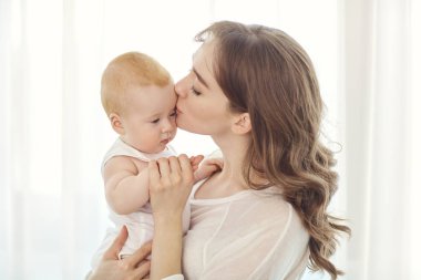 Anne kucağında bir bebekle pencereye çalış. 