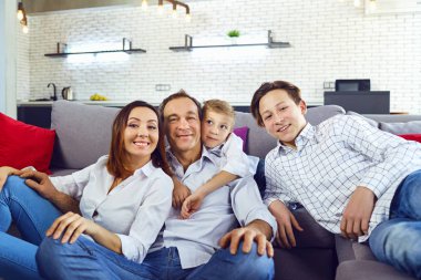 Mutlu aile odasında kanepede oturan gülümseyen.