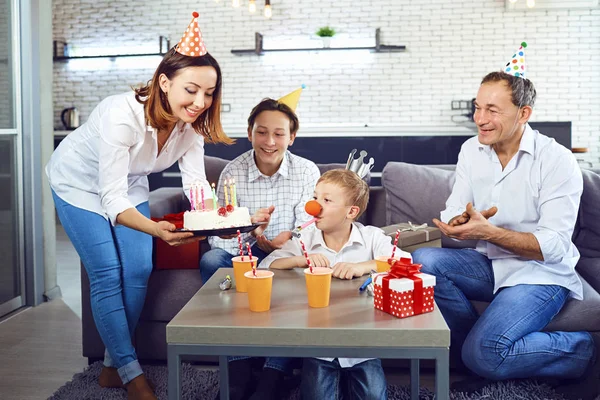 Bir aile bir mum pasta ile bir doğum günü partisi kutluyor.