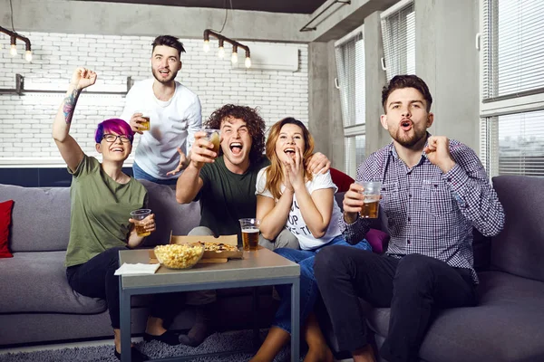 A group of friends are having fun watching TV in the room. — Stock Photo, Image