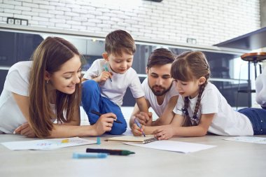 Boş zamanlarında yerde yatarken kağıt üzerinde bir aile çizer.