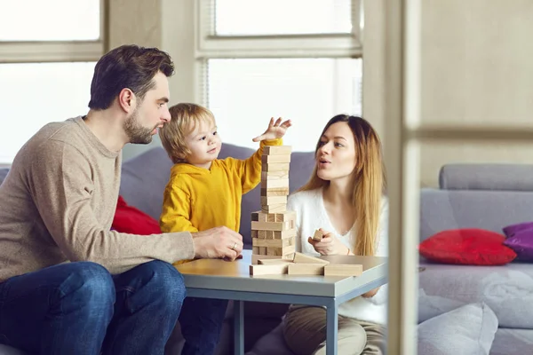 Ein Kind mit seinen Eltern spielt Tischspiele auf dem Tisch. — Stockfoto