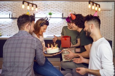 Arkadaş grubu doğum günü kutluyor mumlar ile pasta.