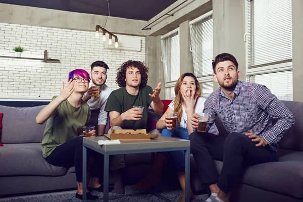 Een groep vrienden plezier kijken Tv in de kamer. — Stockfoto