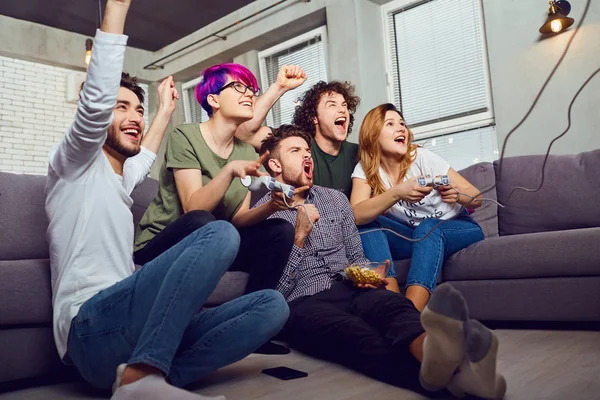 Μια ομάδα φίλων παίζοντας βιντεοπαιχνίδια που κάθεται στον καναπέ, στο — Φωτογραφία Αρχείου