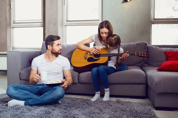 家族一緒にギターを弾き、歌を歌っています。. — ストック写真