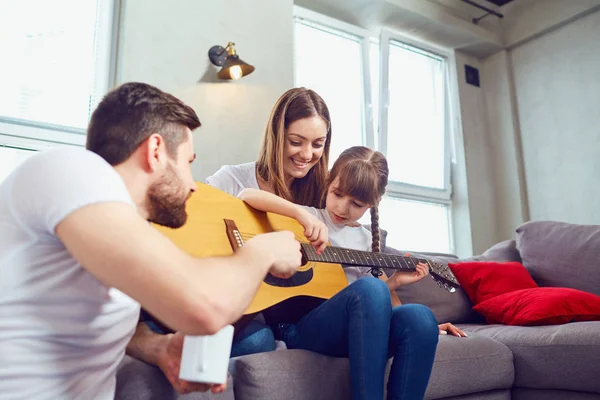 De familie samen gitaar speelt en zingt liedjes. — Stockfoto