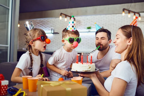 En lycklig familj med en tårta firar en födelsedagsfest. — Stockfoto