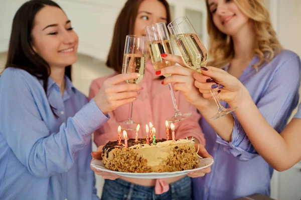 A cake with candles for the birthday in the hands of the girls c — Stock Photo, Image