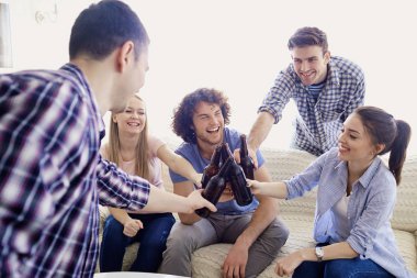 Bir grup arkadaşıyla birlikte bir toplantı odasında şişe tungur vardır