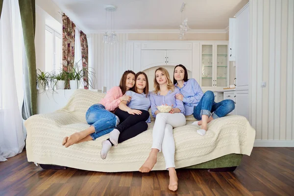 Girlfriends watch TV sitting on the couch. — Stock Photo, Image