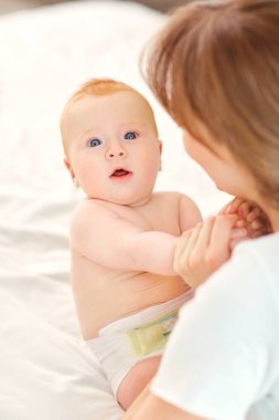 Mutlu anne bebek yatakta kapalı oturma ile. 