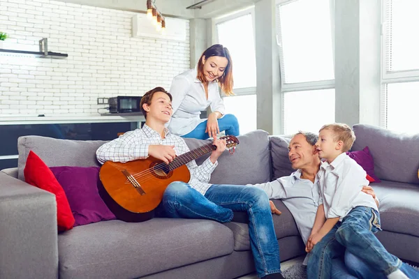 Família feliz com canções de canto de guitarra na sala . — Fotografia de Stock