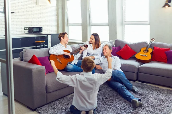 Boldog család gitár énekelnek a szobában. — Stock Fotó