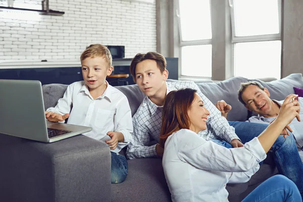 Bir dizüstü bilgisayar ile mutlu bir aile eğleniyor. — Stok fotoğraf