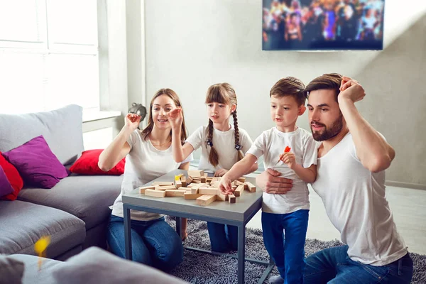 Mother, father and children play together.