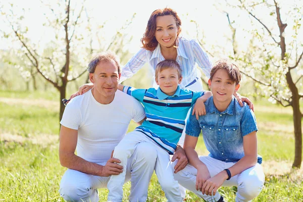 Famiglia felice seduta sulla natura in primavera, estate . — Foto Stock