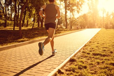 Bir erkek atlet parkında çalışıyor.