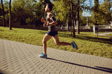 Parka yol boyunca bir erkek atlet çalışır.