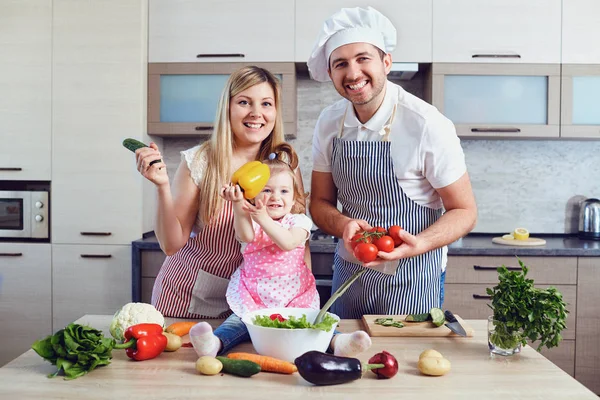 Une famille heureuse prépare la nourriture dans la cuisine . — Photo