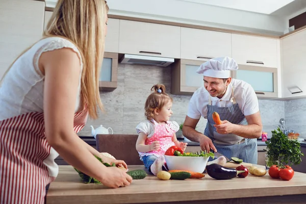 A happy family prepares food  in the kitchen. — Stock Photo, Image