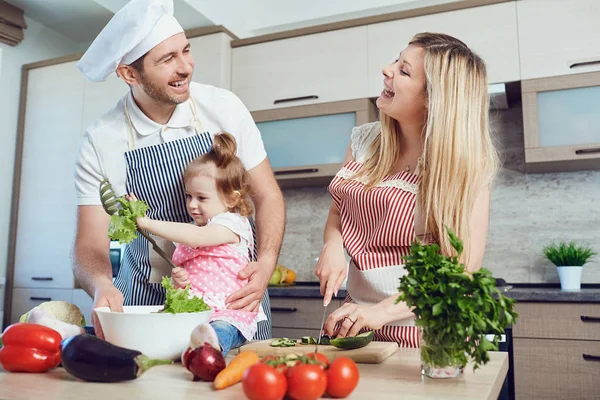 A happy family prepares food  in the kitchen. — Stock Photo, Image