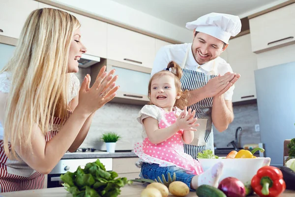 A happy family prepares food  in the kitchen. — Stock Photo, Image