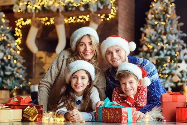 Familia feliz sonriendo con regalos en una habitación en Navidad —  Fotos de Stock